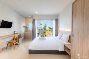 a bedroom with a bed and a desk and a window at Double A Cozy Living in Canggu +47 photos