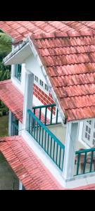 a house with a red roof and a balcony at Misty Hill Land in Meppādi