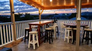 a porch with two tables and stools on a balcony at The Tree House Port Vila in Port Vila
