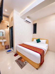 a bedroom with a large bed and a bathroom at Khách Sạn The Second in Thốt Nốt