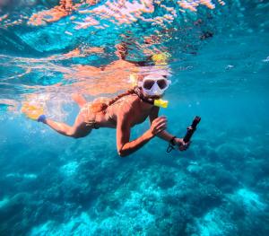 a woman swimming in the water with a bottle at Modo homestay komodo village in Komodo