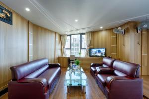 a living room with leather couches and a table at SAILING TOWER Hotel in Khang Qui