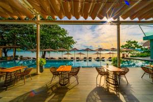 a patio with tables and chairs next to a pool at My Beach Resort Phuket, Panwa Beach in Panwa Beach