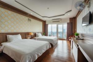 a hotel room with two beds and a large window at SAILING TOWER Hotel in Khang Qui +52 photos
