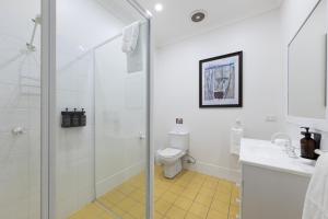 a bathroom with a shower and a toilet and a sink at Audrey Wilkinson Vineyard in Pokolbin
