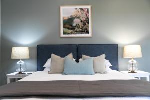 a bedroom with a large bed with two lamps at Audrey Wilkinson Vineyard in Pokolbin