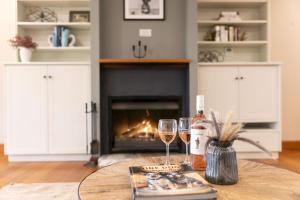 a table with two glasses of wine and a fireplace at Audrey Wilkinson Vineyard in Pokolbin