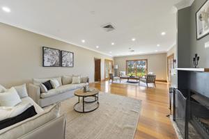 a living room with a couch and a fireplace at Audrey Wilkinson Vineyard in Pokolbin +62 photos