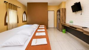 a hotel room with two beds and a flat screen tv at Ventions Sharia Hotel in Jomblang