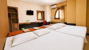 a group of three beds in a room at Ventions Sharia Hotel in Jomblang