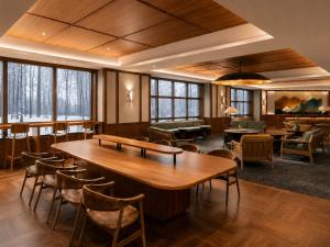 a large room with tables and chairs and windows at Mercure Niseko Resort Formerly known as Midtown Niseko in Kutchan