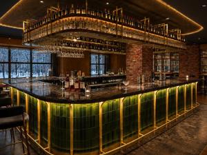 a bar in a restaurant with a large window at Mercure Niseko Resort Formerly known as Midtown Niseko in Kutchan