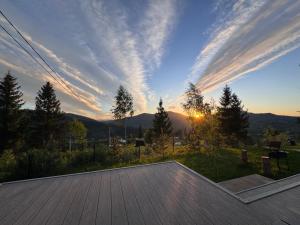 a view of the sunset from the deck of a house at Лісогори in Slavske