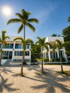 a building with palm trees in front of it at Binucot Pearl Boutique Resort in Ferrol