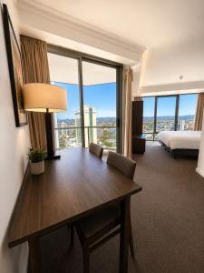 a hotel room with a table and a bed at Stunning City View Beachfront Apartment in Gold Coast +3 photos