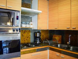a kitchen with wooden cabinets and a sink and a stove at Refugio en Camino a Farellones in Lo Barnechea