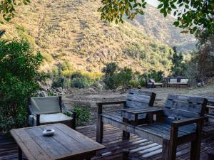 a wooden table and a chair and a table and a table and bench at Refugio en Camino a Farellones in Lo Barnechea