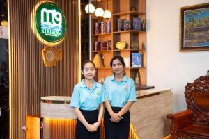 two women in blue shirts standing in a restaurant at M9 Kirirom Hotel in Phnom Penh