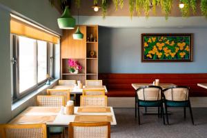 a restaurant with tables and chairs and a painting on the wall at M9 Kirirom Hotel in Phnom Penh