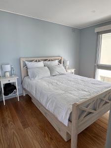 a bedroom with a large bed with a wooden frame at Gate Access to the Beach in Edithvale