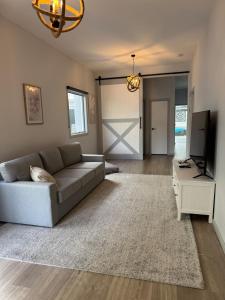 a living room with a couch and a tv at Gate Access to the Beach in Edithvale