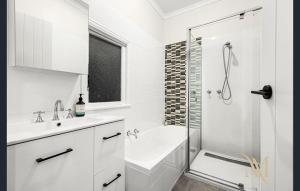 a white bathroom with a shower and a sink and a tub at Gate Access to the Beach in Edithvale +20 photos