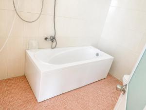 a white bath tub in a bathroom with a shower at Khách sạn Thu Hòn Rơm Phan Thiết in Phan Thiet