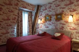 a bedroom with a bed with red sheets and a window at Neuilly Park Hotel in Neuilly-sur-Seine