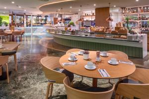 a restaurant with wooden tables and chairs and a counter at Meliá Barcelona Sarrià in Barcelona