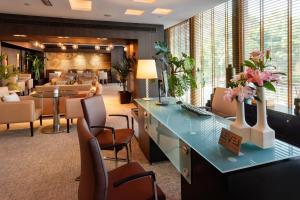 a lobby with a waiting room with tables and chairs at Meliá Barcelona Sarrià in Barcelona