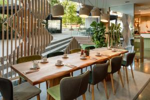 a dining room with a wooden table and chairs at Meliá Barcelona Sarrià in Barcelona