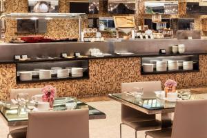 a restaurant with two tables and a counter with dishes at Meliá Barcelona Sarrià in Barcelona
