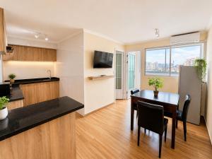 a kitchen and dining room with a table and a refrigerator at Hotel Asia Pacifico in Santiago