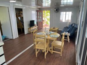 a dining room and living room with a table and chairs at Aore Shores Beachfront Bungalow in Aore Island