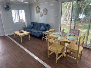 a living room with a table and a couch at Aore Shores Beachfront Bungalow in Aore Island +3 photos