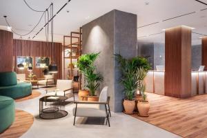 a lobby with potted plants and tables and chairs at Meliá Granada in Granada