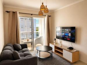 a living room with a couch and a tv at Oceanfront AC Wi-Fi Coffee Summer vacation in La Cana