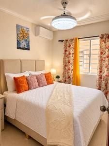 a bedroom with a large white bed with colorful pillows at Oceanfront AC Wi-Fi Coffee Summer vacation in La Cana