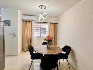 a dining room table with chairs and a vase with flowers at Oceanfront AC Wi-Fi Coffee Summer vacation in La Cana