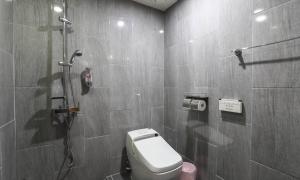 a bathroom with a shower and a toilet in it at Hotel H2 in Ulsan