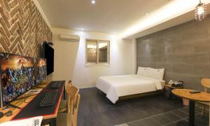a bedroom with a bed and a desk with a computer at Hotel H2 in Ulsan