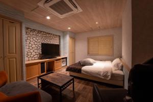 a bedroom with a bed and a tv in a room at MONI hotel in Atsugi +3 photos
