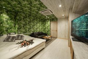 a bedroom with a bed and a large screen tv at MONI hotel in Atsugi