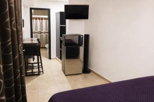 a bedroom with a tv on a wall and a mirror at Estudio compacto en Riviera Diamante con alberca in Acapulco