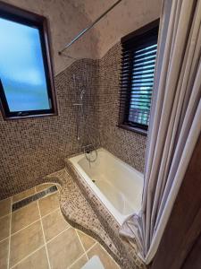 a bathroom with a bath tub with a window at WAAP Hotel in Ishigaki Island +28 photos