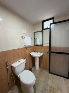 a bathroom with a white toilet and a sink at SIORA Retreat in Dambulla