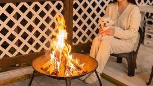 a woman sitting next to a fire pit with a teddy bear at Taean anmyeondo hwangdo ilmare Pension in Taean +2 photos