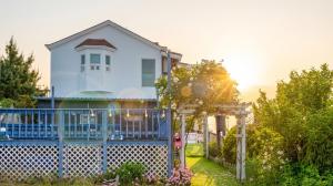 a house with a blue fence in front of it at Taean anmyeondo hwangdo ilmare Pension in Taean