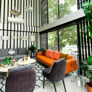 a living room with an orange couch and chairs at S-Cape at Rim Khwae in Ban Tha Thong Mon