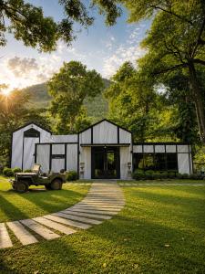 a house with a car parked in the grass at S-Cape at Rim Khwae in Ban Tha Thong Mon
